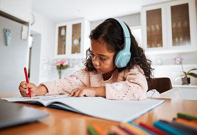 Buy stock photo Young child, learning and homeschool with headphones for homework, writing and drawing in books. Childhood development, focus and girl kid listening to audio while studying for kindergarten education