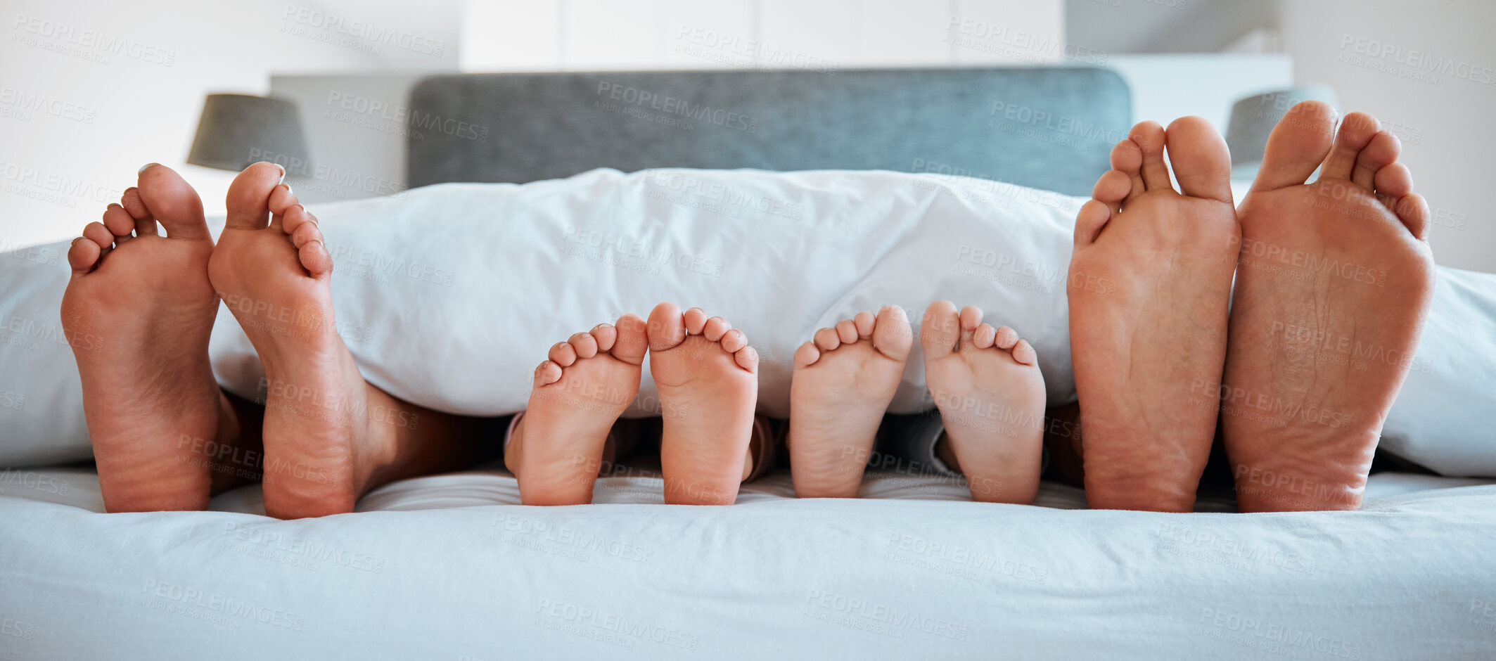 Buy stock photo Family feet, bed and blanket in closeup, parents or kids sleeping on holiday in morning, care and relax. Bedroom, people and sleep with mom, dad or children on vacation, home or break in hospitality