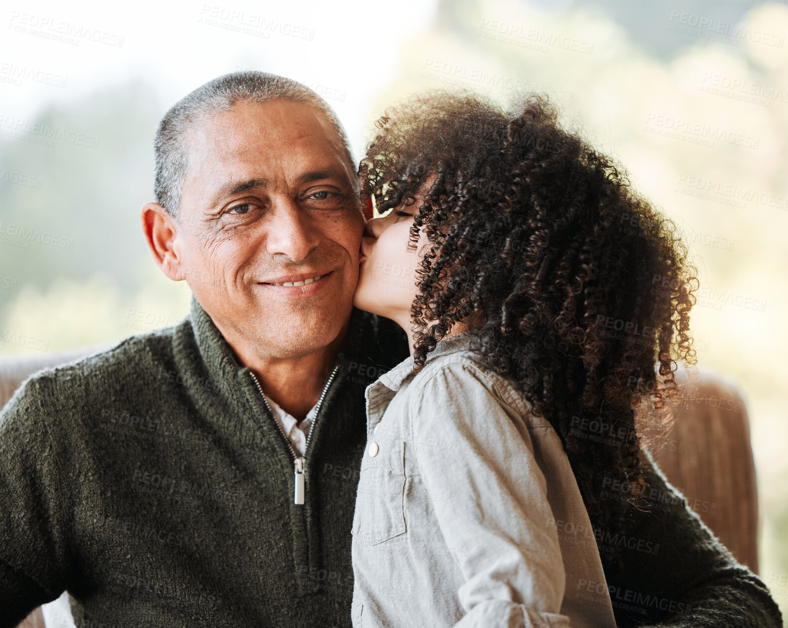 Buy stock photo Grandfather, kid and kiss cheek in home living room, smile or portrait for love, care and bonding. Senior man, young child and happy with quality time, retirement and relax with hug in family house