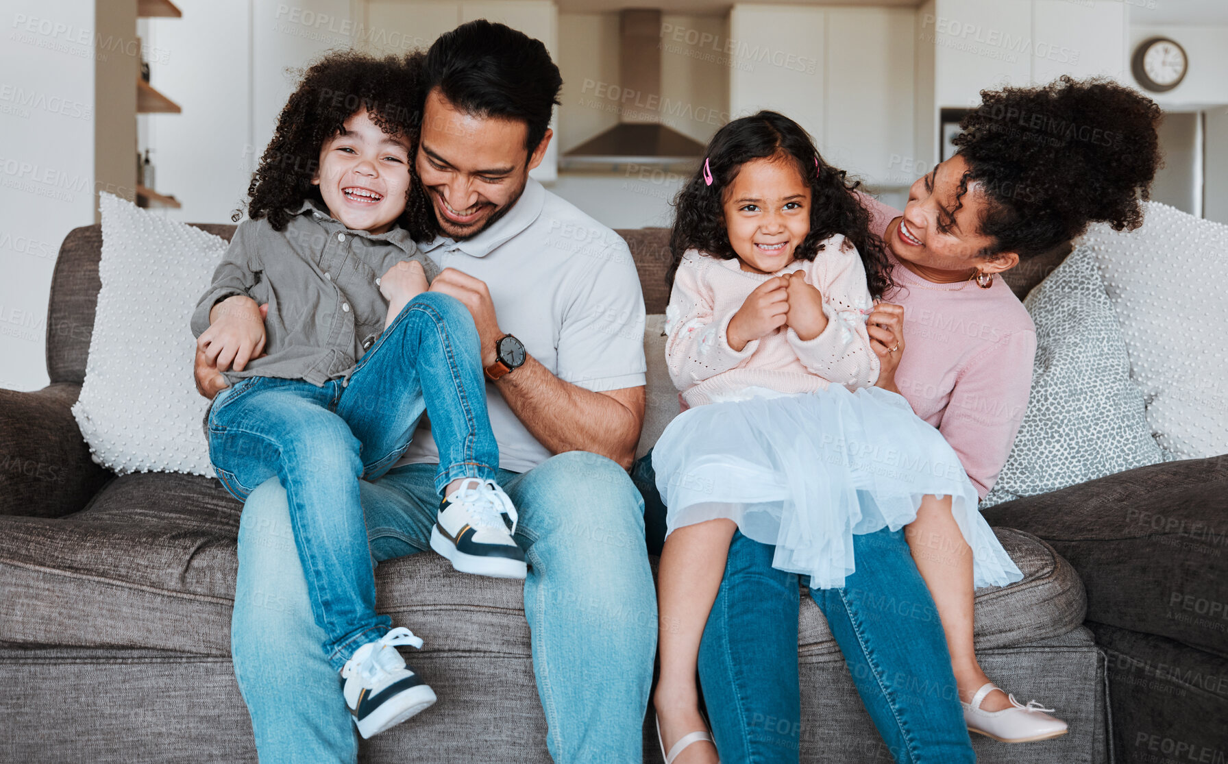 Buy stock photo Mother, father and kids on sofa, playing and happy family bonding together in living room. Smile, happiness and parents relax with young children on couch, playful and spending quality time in Mexico