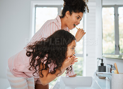 Buy stock photo Mom, girl cleaning teeth and together in bathroom with toothbrush, toothpaste and morning routine in family home. Kid, mother and brushing tooth for hygiene, grooming and teaching healthy dental care