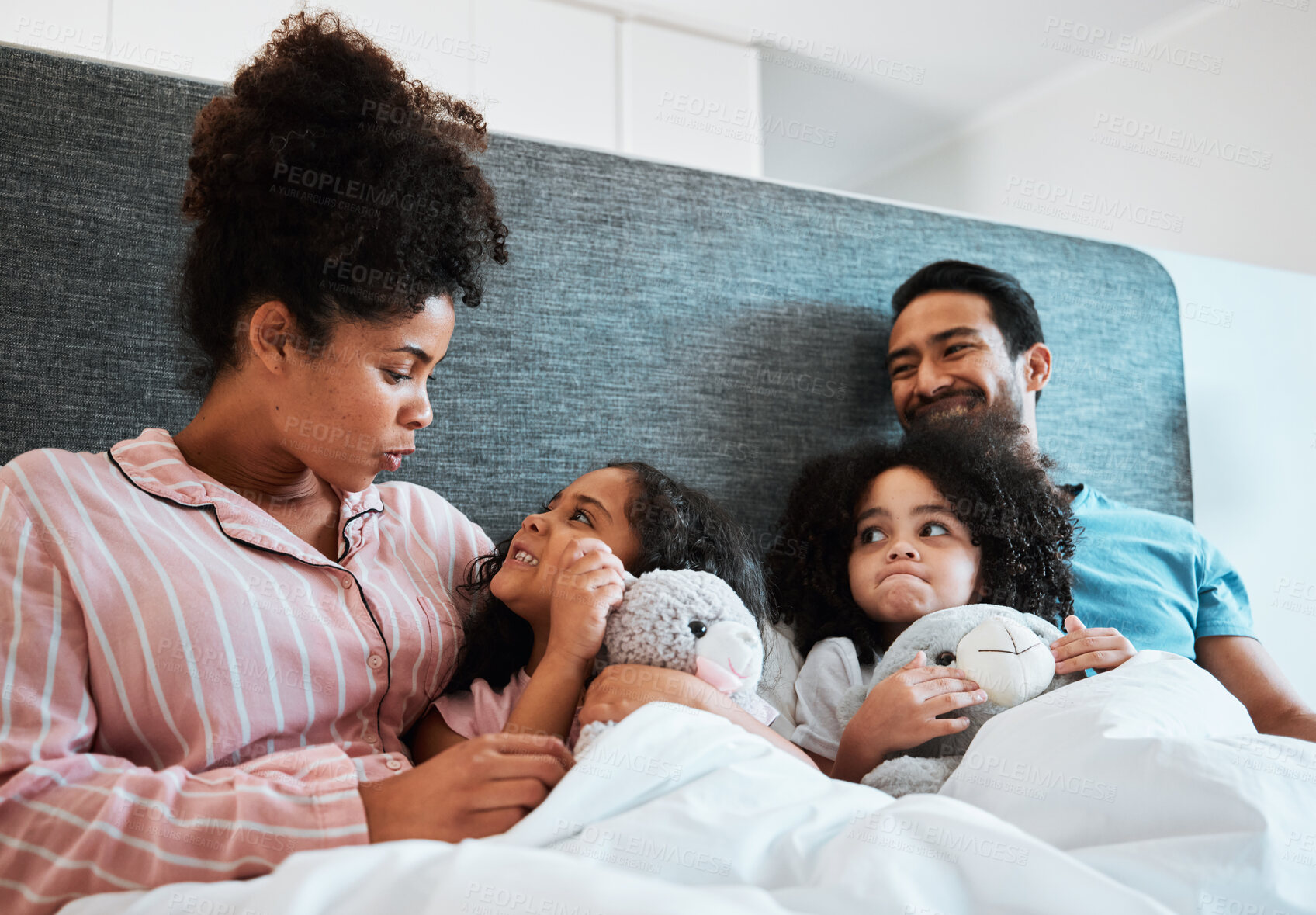 Buy stock photo Love, conversation and kids laying with their parents in their bedroom talking, relaxing and bonding. Happy, smile and girl children speaking and resting with their mother and father at their home.