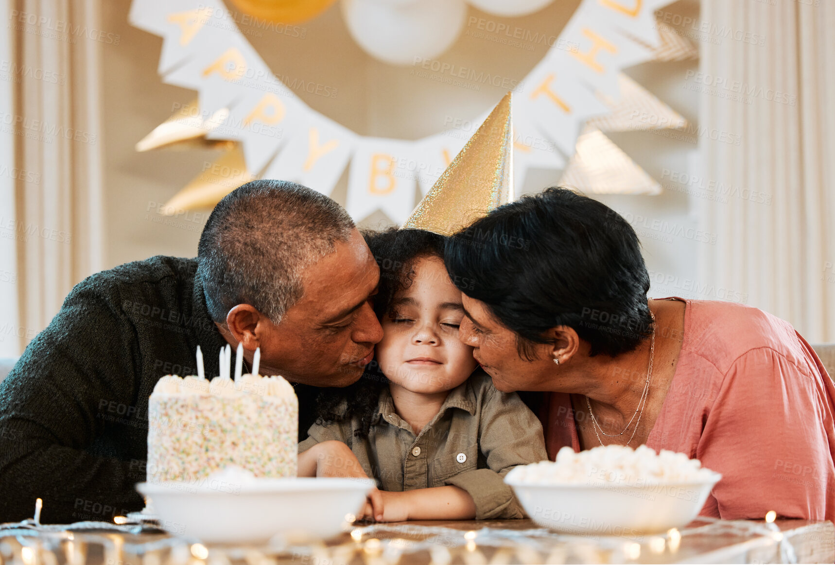 Buy stock photo Birthday, cake and grandparents kiss child in living room for event, party celebration and social gathering. Happy, surprise and grandma, grandpa and kid with dessert, snacks and presents at home