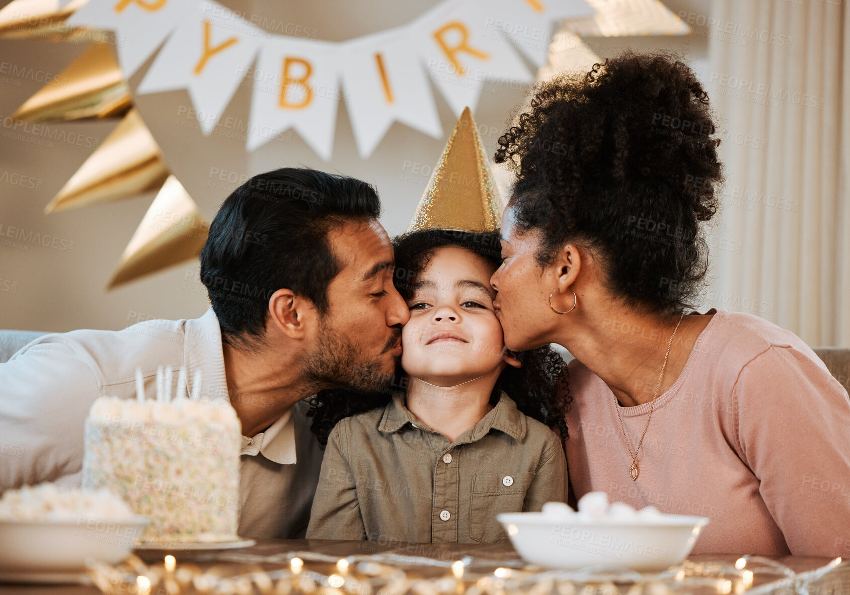 Buy stock photo Father, mother and child at birthday party, kiss and happy with celebration, care and bonding in family house. Dad, mom and young kid with event, excited face and love together at table in apartment