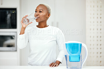 Buy stock photo Woman, filter and drinking water for health at home for a healthy lifestyle, diet and nutrition. Young african person with a glass from a container or pitcher in a kitchen for detox and wellness  