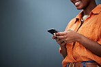 Typing, mockup and hands with a phone on a dark background for communication or social media. Smile, space and a black woman with a mobile for an app or chat isolated on a studio backdrop for web