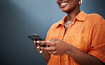 Typing, happy and hands with a phone on a dark background for communication or social media. Smile, contact and a black woman with a mobile for an app or chat isolated on a studio backdrop for web