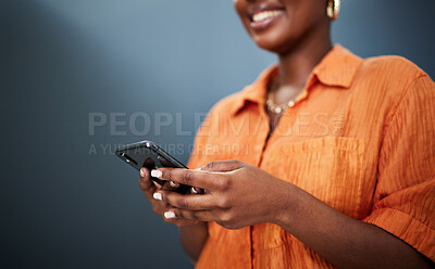 Buy stock photo Typing, happy and hands with a phone on a dark background for communication or social media. Smile, contact and a black woman with a mobile for an app or chat isolated on a studio backdrop for web