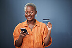 Smile, phone and credit card with a black woman online shopping in studio on a gray background. Mobile, ecommerce and finance payment with a happy young female shopper searching for a deal or sale