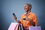 Bags, shopping and black woman with a credit card, cellphone and ecommerce on a grey studio background. Female person, shopper or model with smartphone, boutique items or payment with retail or smile