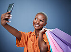 Selfie, happy and woman with shopping bags in studio after sale, promotion or discount. Smile, excited and African female person or customer taking picture after buying products by gray background.