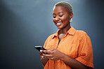 Phone, texting and happy black woman in studio for social media, app or communication on grey background. Smartphone, search and African female smile for meme, post or online dating notification