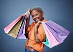 Happy, portrait and woman with shopping bags in studio after sale, promotion or discount. Smile, excited and luxury African female customer posing after buying products isolated by a gray background.