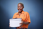 Black woman, present package and surprise in studio with excited smile, birthday and blue background. African girl, happy and wow with box, gift and fashion for celebration, winner and birthday party