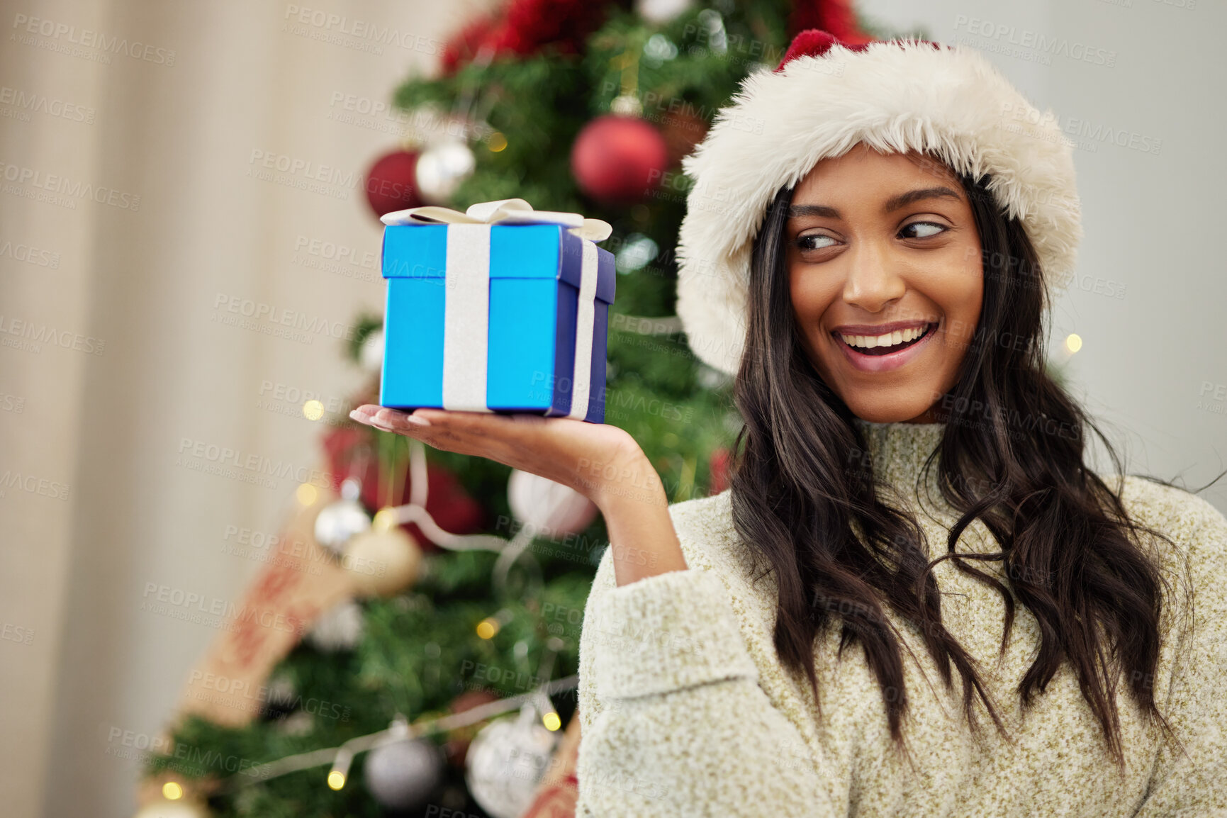 Buy stock photo Christmas, thinking or happy woman with a gift or box in present on a holiday celebration at home. Curious, smile or excited Indian girl with present with giveaway prize package in a house in winter 