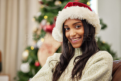 Buy stock photo Happy woman, portrait and Christmas on sofa by tree with hat for festive season, celebration or gift at home. Female person with smile in relax for holiday, weekend or December party at the house