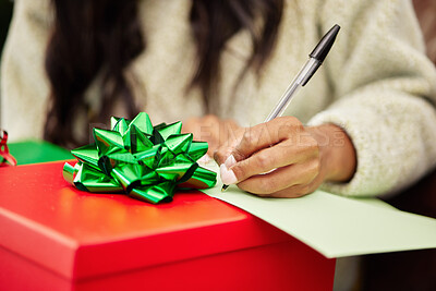 Buy stock photo Woman, hands and writing on Christmas gift, note or letter in surprise, festive season or December holiday. Hand of female person with pen and paper on present or box with ribbon for package in house