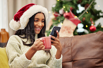 Buy stock photo Christmas, happy woman and phone on home sofa with a smile and coffee for online communication. Indian female person with a smartphone and hot chocolate for festive holiday, social media or internet