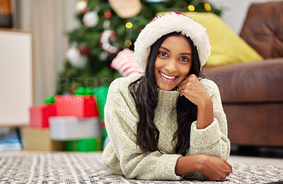 Buy stock photo Christmas, happy woman and smile portrait on home floor with a positive mindset. Face of Indian female person on a lounge carpet to relax for festive holiday, season or celebration with a hat