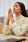 Religion, prayer and young woman in her living room with christian faith, gratitude and worship. Spiritual, hope and religious female person praying with her hands together to god in her modern home.