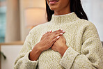 Closeup of a woman holding her chest while breathing for calm, peace and zen mindset for meditation. Breathe, relax and zoom of a female person hands on her heart for grateful gesture in living room.