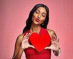 Kiss, heart and valentines day with a woman on a pink background in studio for love or romance. Red lips, emoji and social media with a happy young female holding a shape or symbol of affection