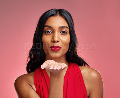 Buy stock photo Woman, red lipstick and beauty, blow kiss with makeup and flirt, cosmetics and glow on pink background. Cosmetology, Indian female model pout with color in portrait and shine with wellness in studio