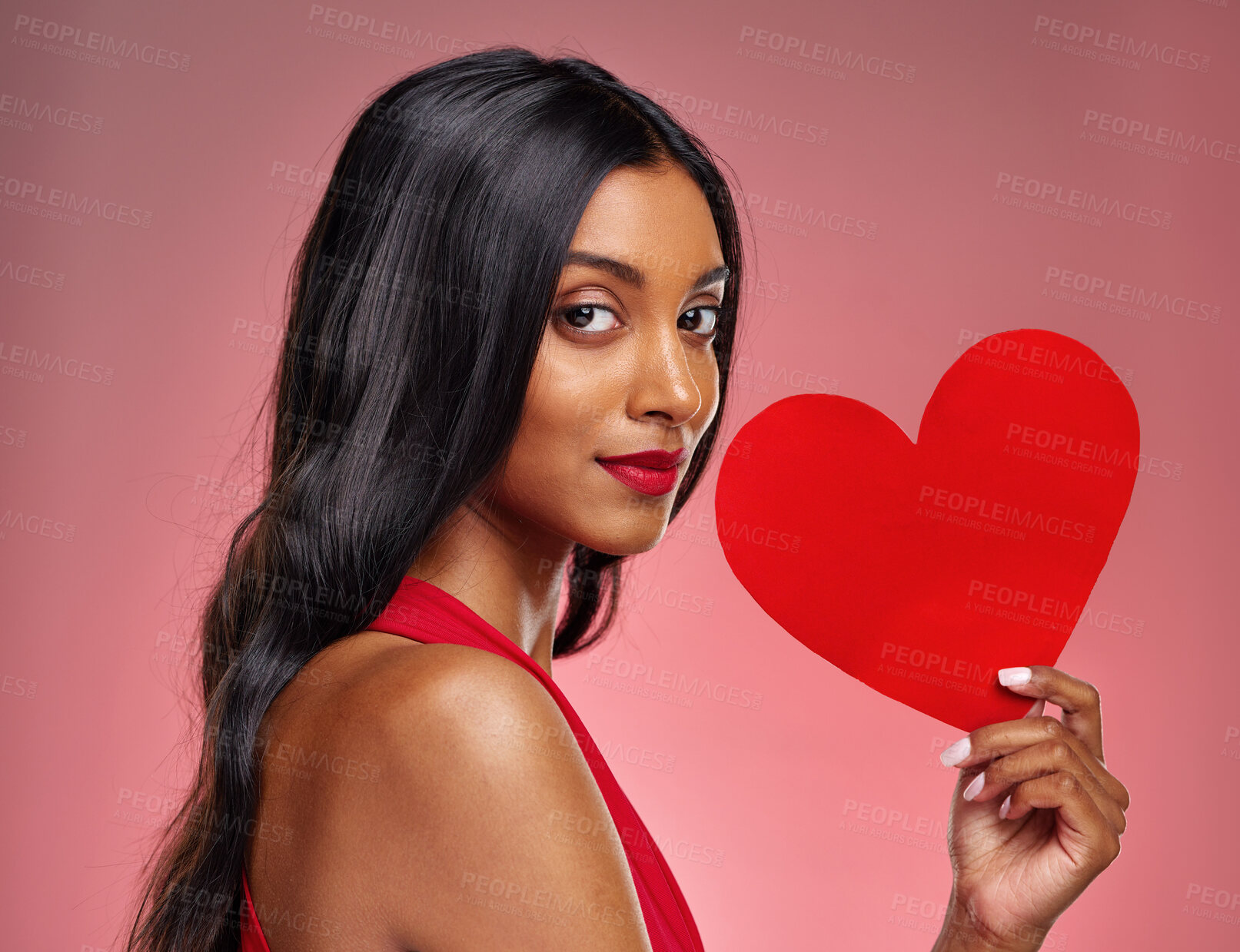 Buy stock photo Portrait, heart and love with a woman on a pink background in studio for romance on valentines day. Face, emoji and social media with a confident young female holding a shape or symbol of affection