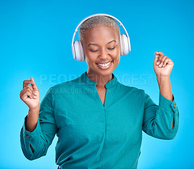 Buy stock photo Black woman, headphones and studio with dancing, smile and listen to music by blue background. Young gen z student, sound tech and happy for audio streaming subscription, radio or excited with dance