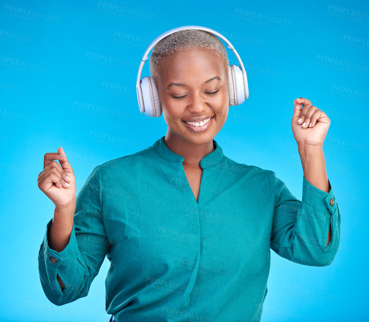 Buy stock photo Black woman, headphones and studio with dancing, smile and listen to music by blue background. Young gen z student, sound tech and happy for audio streaming subscription, radio or excited with dance