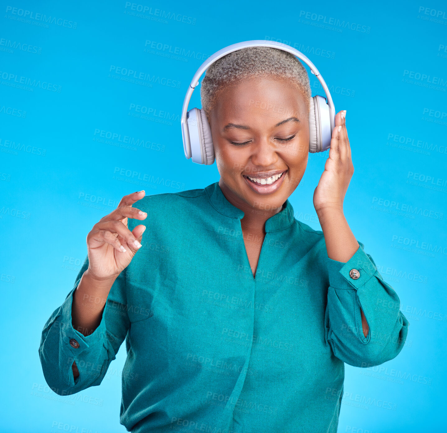 Buy stock photo African woman, headphones and studio for listening, music and smile with dancing by blue background. Young gen z student, sound tech and happy for audio streaming, online radio and excited with dance