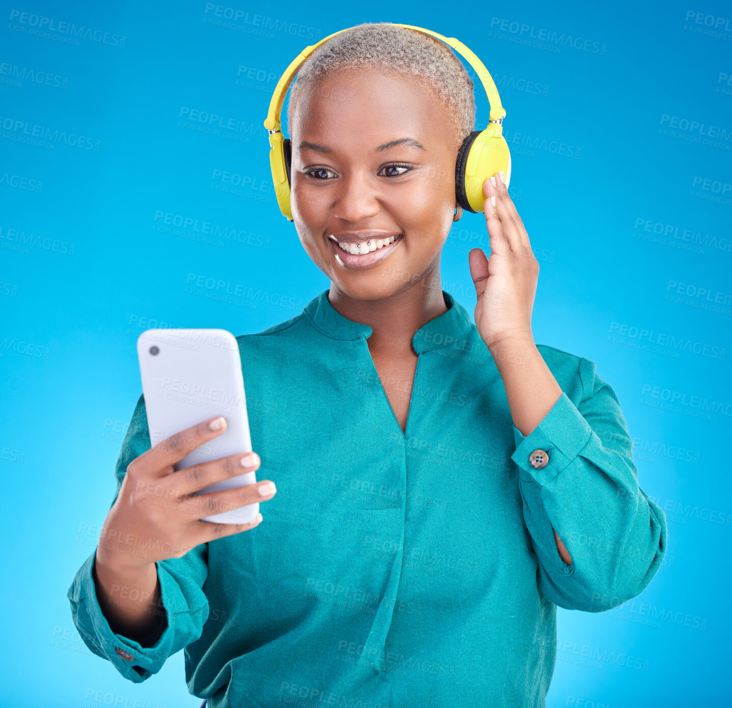 Buy stock photo Headphones, phone and woman listening on studio, blue background for podcast, music and streaming service. Mobile, audio technology and young african woman on electronics for radio, sound or hearing