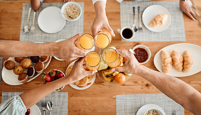 Buy stock photo Lunch, hands and people toast with orange juice, beverage or glass drinks at lunch, brunch or food meal. Fruit liquid, top view group and home family solidarity, celebrate and cheers at social event