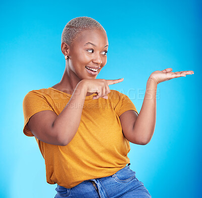 Buy stock photo Decision, pointing and black woman with a smile, presentation and advertising on a blue studio background. Sales, female person or model with discount deal, sales and choice with promotion or showing