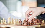 Chess, board game and hand of a man playing at a table while moving piece for strategy or checkmate. Person with wooden icon to play, relax and bond or problem solving and battle in competition 