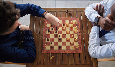 Buy stock photo Chess, board game and business men playing at a table from above while moving piece for strategy. Male friends together to play, relax and bond with icon for problem solving, challenge or checkmate