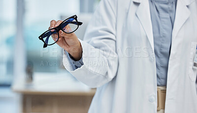 Buy stock photo Optometry, health and closeup of a optometrist with glasses at optical store or clinic. Eye care, wellness and zoom of optician or medical worker with prescription spectacles or eyewear frame at shop
