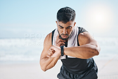 Buy stock photo Man, fitness and checking watch for pulse, heart rate or performance on break after workout on the beach. Fit, active and sporty male person with wristwatch for monitoring body exercise by the ocean