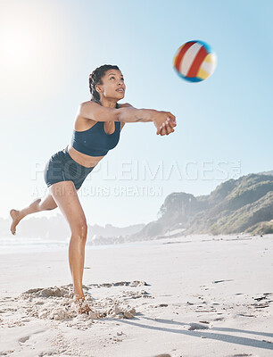 Woman, volleyball and hitting on beach in sports game, match or competition over net in the outdoors. Female person or player in volley or spiking ball up for fitness, point or athletics by the ocean
