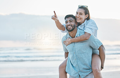 Buy stock photo Couple, piggyback on beach and love, travel and holiday, mockup space and happy together outdoor. Summer, support and care with affection, man and woman pointing in nature with adventure by the ocean