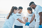 Volunteering, team huddle and cleaning beach for world earth day, care for nature and environment. Help, recycle and support in teamwork, group of people at ocean to clean plastic waste and pollution