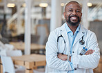Portrait, black man and happy doctor with arms crossed in hospital for healthcare. African medical professional, face and surgeon, person or confident employee from Nigeria with smile for wellness.