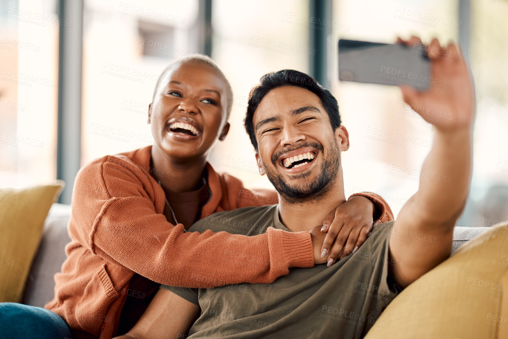 Buy stock photo Home, selfie and couple on a couch, smile and loving together with romance, profile picture and marriage. Social media, black woman or Asian man on a sofa, romantic and memory with happiness or relax