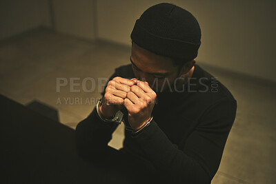 Buy stock photo Interrogation, worry and criminal with handcuffs in jail for investigation, stealing and theft in station. Arrested suspect, law and man praying with anxiety, worry and scared in prison for crime