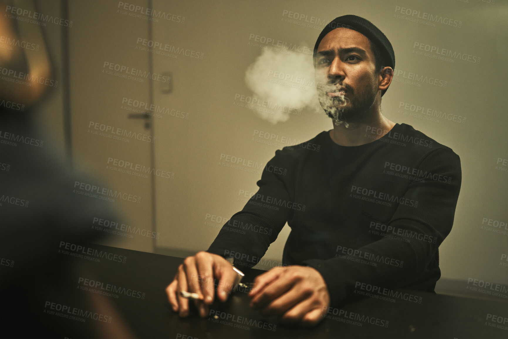 Buy stock photo Man in handcuffs, smoking and talking to detective in interrogation room with criminal, suspect or interview with a gangster. Police officer, questioning in arrest and person in investigation