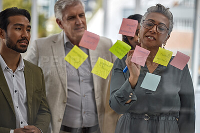 Buy stock photo Meeting, planning and glass with a senior woman leading a presentation in a boardroom for company strategy. Teamwork, presentation and sticky notes in an office with a female manager talking to staff