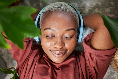 Buy stock photo Woman, face and headphones for listening to music to relax on a floor with plants for peace and calm. Headshot of a black female person meditate with sound, audio and podcast or radio at home