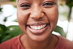 Portrait, plants and teeth with a black woman gardener in her home for sustainability or green growth. Face, flare and smile with a happy young female person in a nursery for eco friendly gardening