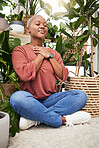 Calm, peace and young woman by plants for breathing exercise in meditation in a greenery nursery. Breathe, gratitude and African female person with a relaxing zen mindset by indoor greenhouse garden.