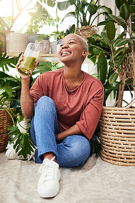 Buy stock photo Healthy, black woman and green juice for nutrition or wellness with smile for diet in home with plant. Vegetarian, smile and girl with detox smoothie or shake for weightloss with fruit or vegetable.